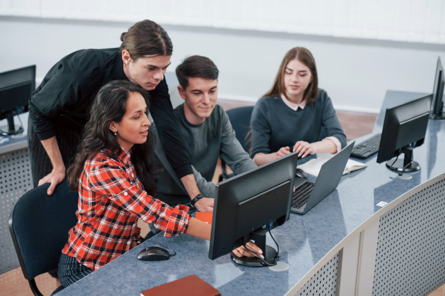 Tech bootcamp students collaborating on coding project in modern classroom
