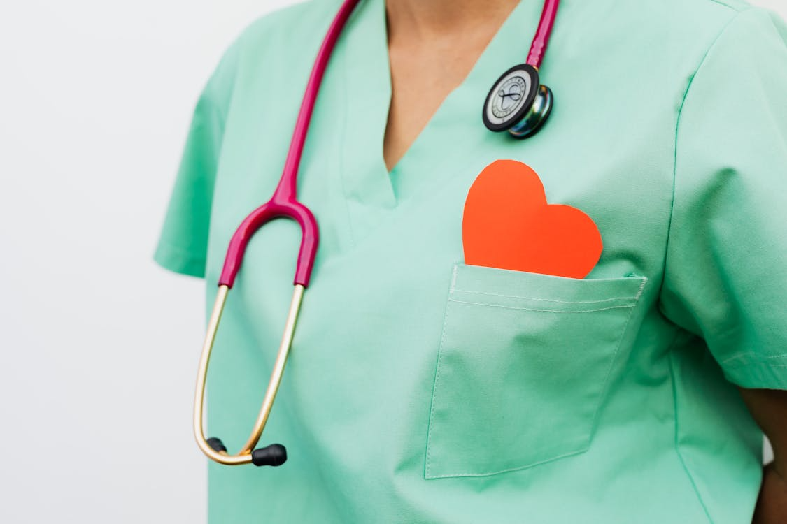 Healthcare worker in green scrubs with a stethoscope