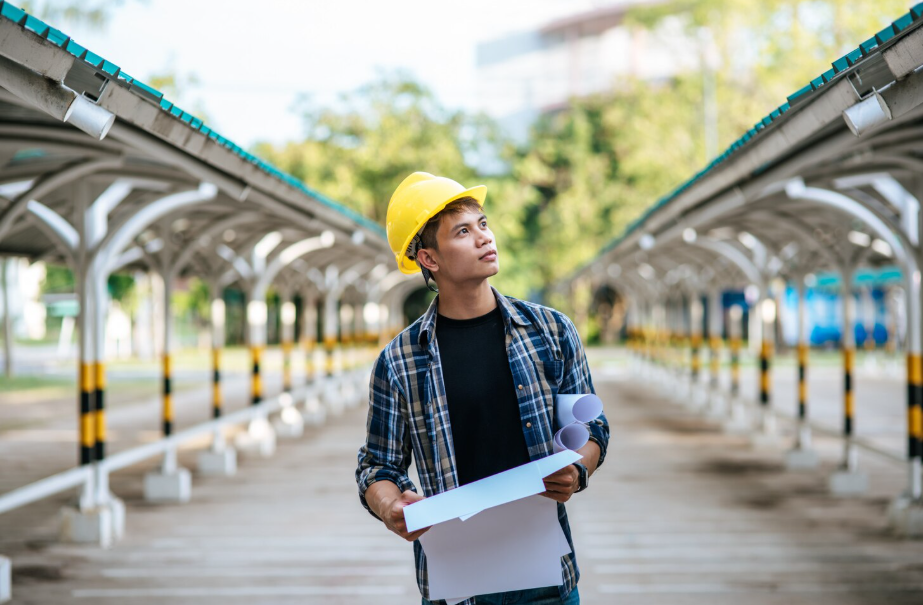 Trade school student in a hard hat holding blueprints representing hands-on career training