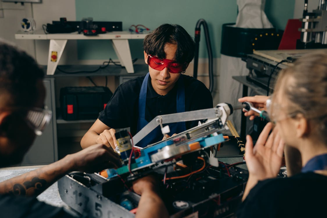 Group of apprentices building and testing a robotic machine during hands-on training