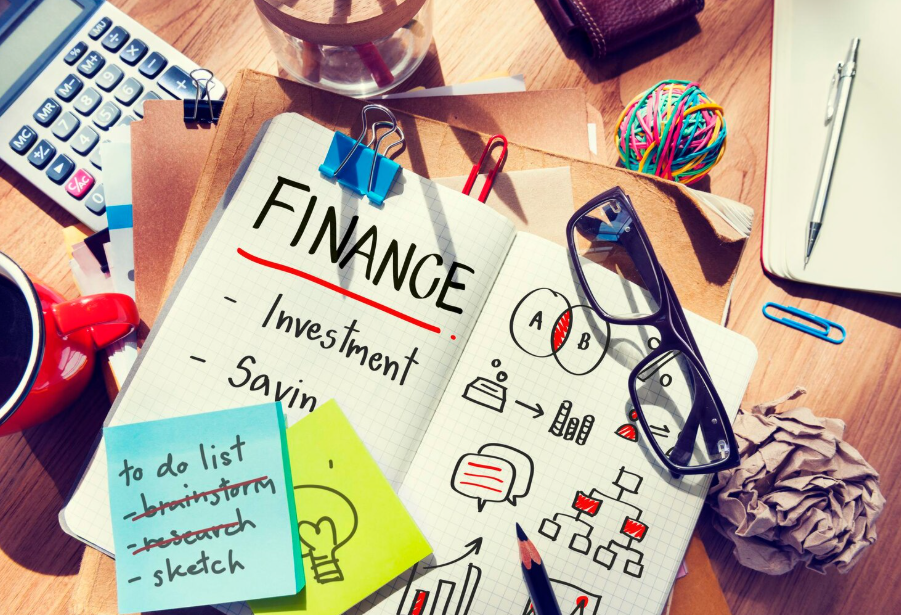 Notebook with finance notes on investment and saving with calculator for student financial planning